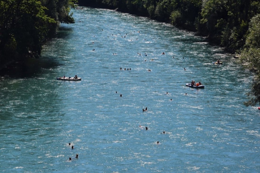 Families floating tubes down the clear blue Provo River on a sunny day